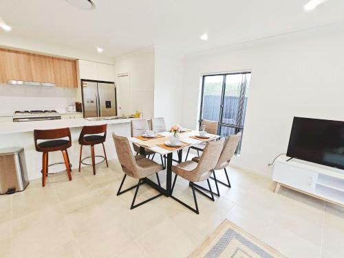 a kitchen and dining room with a table and chairs at Colebee 5 Bedroom near Shopping WiFi Central AC in Schofields