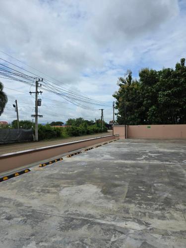 an empty parking lot next to a fence at One Budget Hotel Nan Pha Sing โรงแรม วัน บัดเจท น่าน ผาสิงห์ in Nan