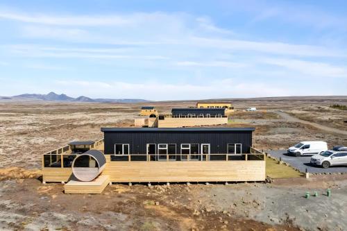 a house in the middle of a desert with cars parked at Þingvallavatn Hot Tub Sauna 2024 Built Cabin in Veiðilundur