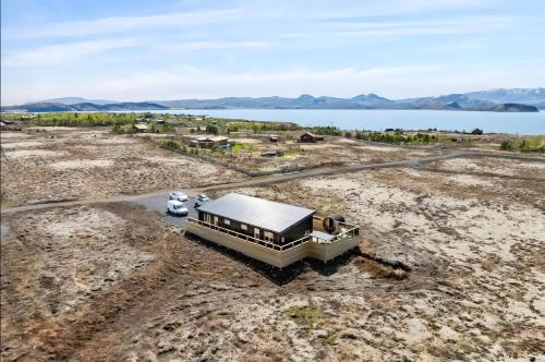 an aerial view of a building in a field with a car at Þingvallavatn Hot Tub Sauna 2024 Built Cabin in Veiðilundur