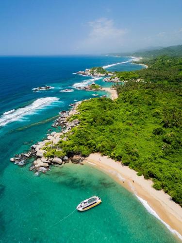 an island with a boat on a beach at Arrecifes Refugio Natural in Santa Marta
