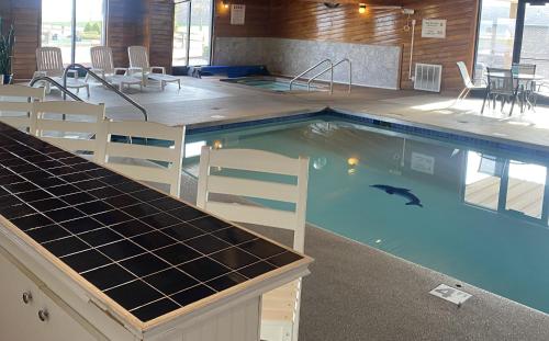 a large swimming pool with chairs and a table at Village Inn on the Lake in Two Rivers