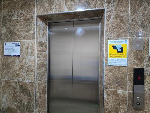 a elevator in a building with a sign on it at One Budget Hotel Nan Pha Sing โรงแรม วัน บัดเจท น่าน ผาสิงห์ in Nan