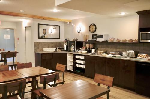 a restaurant with tables and a kitchen with a counter at Glacier Mountain Lodge in Blue River