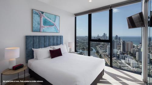 a bedroom with a white bed and a large window at The Star Residences - Gold Coast in Gold Coast