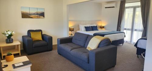 a hotel room with a bed and a couch at The Bealey Hotel in Arthur's Pass