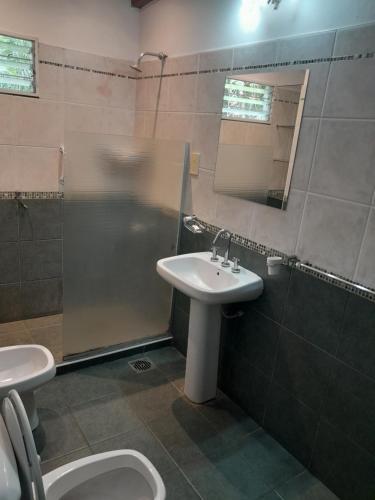 Un baño con lavabo, ducha e inodoro. en El Guerrero Club de Campo, en Colonia Benítez