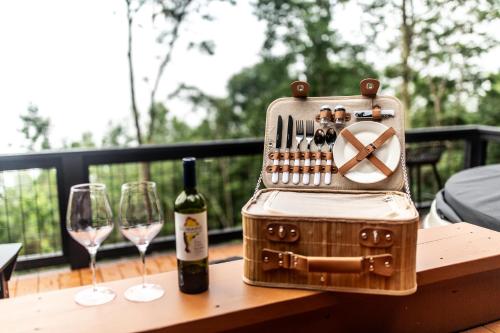 a bottle of wine and two wine glasses on a table at The Spruce Villa where luxury meets nature in Panther Creek