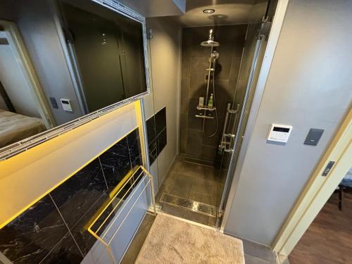 a bathroom with a shower with a glass door at 日月庵 BnB Sunmoon in Kanazawa
