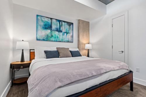 a bedroom with a large bed and a painting on the wall at 8th fl Amazing views! Lux design! Pool gym Pkg! in Salt Lake City