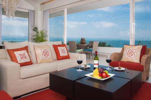 a living room with a couch and a table with a plate of fruit at Marival Distinct All-Suites & World Spa - Handwritten Collection in Nuevo Vallarta 