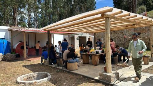 a group of people sitting under a wooden pergola at MAy Loviou in Namora