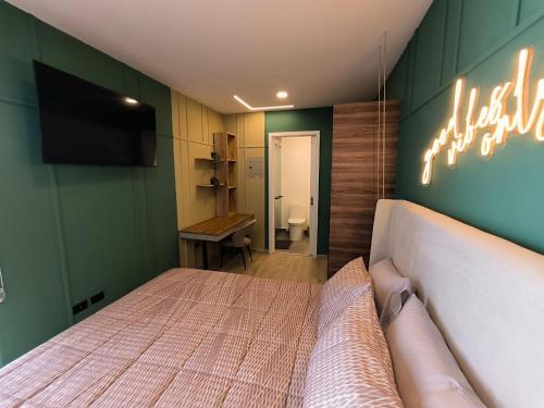 a bedroom with a bed and a television and a bathroom at Republica del Salvador Coliving Ecuador XOE in Quito