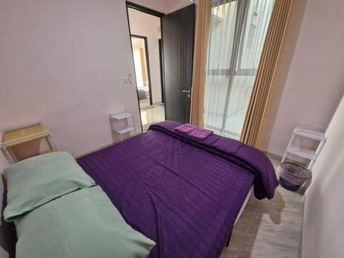 a purple bed in a room with two chairs at Guesthouse Jogja Selatan 2 Yogya South Bantul - Casa of Joy in Bantul