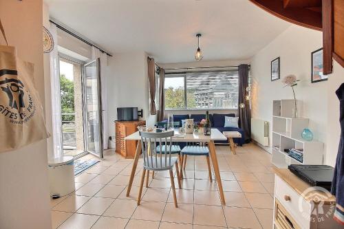 une cuisine et un salon avec une table et des chaises dans l'établissement Le duplex du linkin, à Perros-Guirec