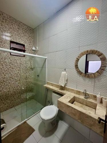a bathroom with a toilet and a shower and a sink at Casa na Praia do Francês in Praia do Frances