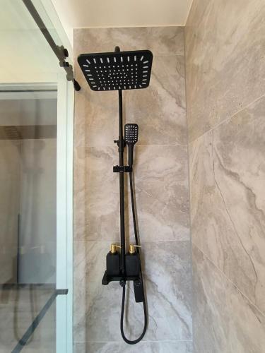 a shower in a bathroom with a shower head at Republica del Salvador Coliving Ecuador XOE in Quito