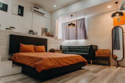 ファンランにあるNhà Bơ Homestayのベッドとソファと椅子のある寝室