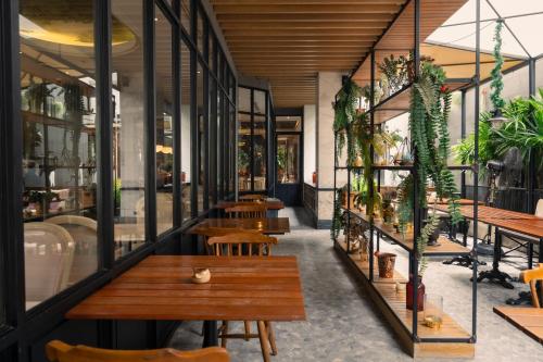 a restaurant with tables and chairs and plants at The Salil Hotel Sukhumvit 57 - Thonglor in Bangkok