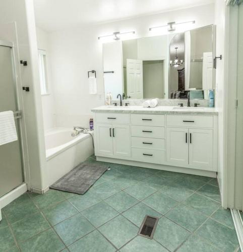 a bathroom with two sinks and a tub and a shower at Large Family Home with Game Room in Page