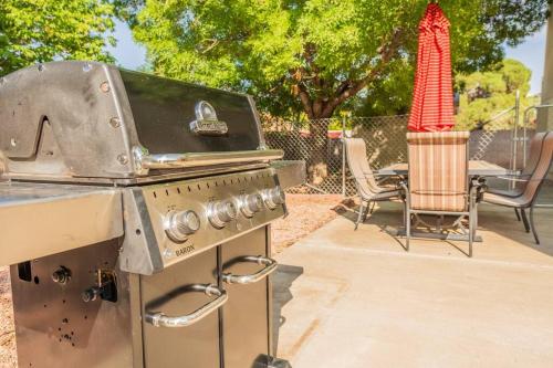 a grill in a backyard with a table and chairs at Large Family Home with Game Room in Page
