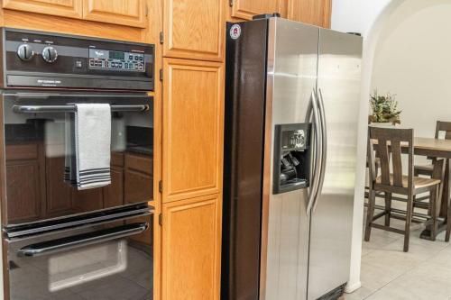a kitchen with a stainless steel refrigerator and a table at Large Family Home with Game Room in Page