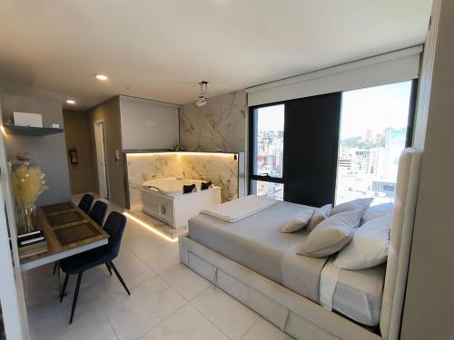 a bedroom with a large bed with a desk and a window at Republica del Salvador Coliving Ecuador XOE in Quito
