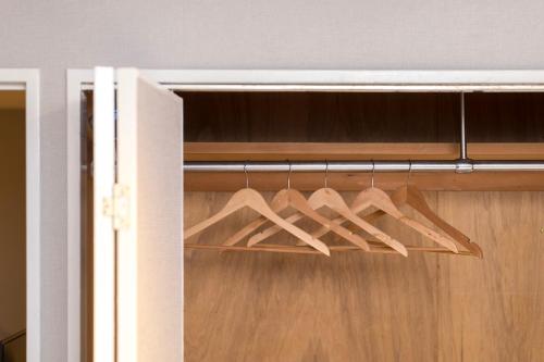a bunch of wooden hangers in a closet at e-stay namba in Osaka