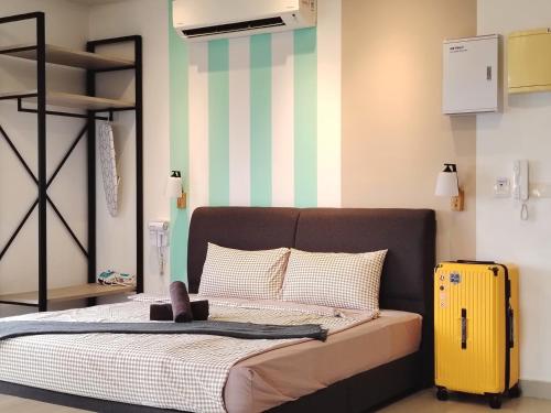 - une chambre avec un lit et une valise jaune dans l'établissement 3706 Meridin Sovo Couple Legoland Netflix BySTAY, à Iskandar Puteri