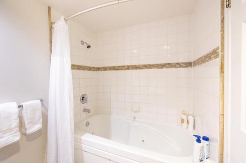 a white bathroom with a tub and a shower at Powderhorn at Whistler Blackcomb in Whistler
