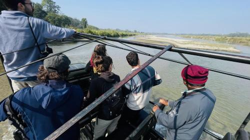 a group of people on a boat on a river at Tree Tops Retreat B&B in Sauraha