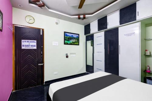a bedroom with a bed and a clock on the wall at Sri Sakthi Home Stay - Beyond the Expectations - We maintain standards in Tirupati