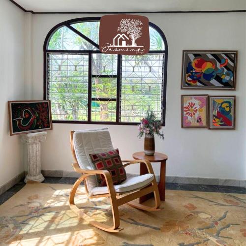a living room with a chair and a window at Bann Jasmine Khaoyai in Mu Si