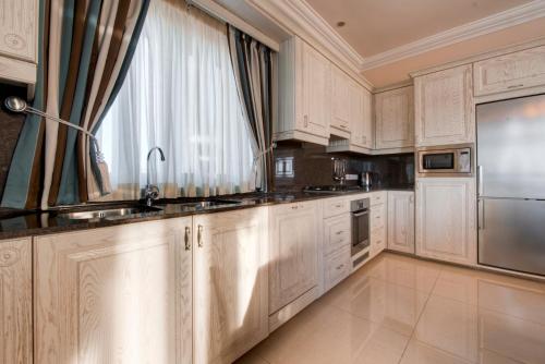 a kitchen with white cabinets and a large window at Villa Munqar in Żurrieq