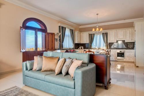 a living room with a couch and a kitchen at Villa Munqar in Żurrieq