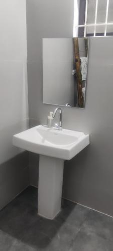 a white sink in a bathroom with a mirror at Aastha homestay in Mysore