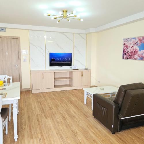 a living room with a couch and a flat screen tv at Omni Suites 1Bed #702A in Bangkok
