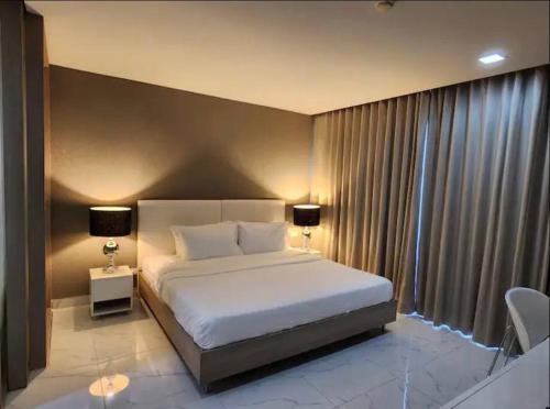 a bedroom with a white bed and a large window at Condominium - Sukhumvit Soi 5 BTS Nana- Room Size 47m2 in Bangkok