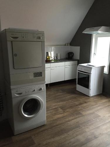 a kitchen with a washing machine and a stove at Hotel Bij Verhoeven in Zevenbergen