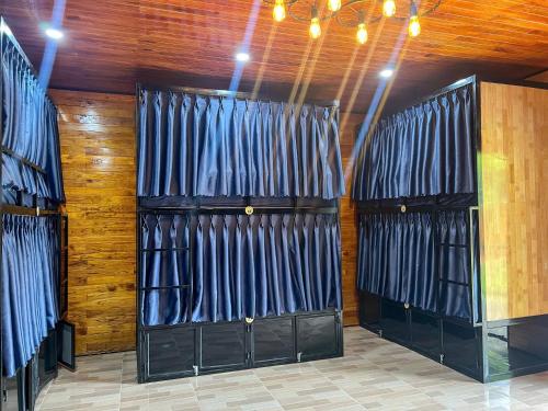 two sets of black doors in a room with wooden walls at Tam Coc Central Bungalow-Hostel in Vũ Lâm