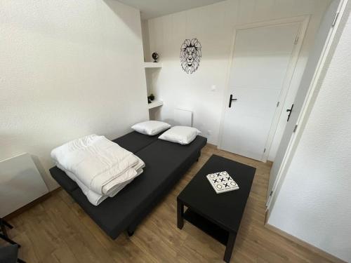 a small room with two beds and a table at Appartement avec du cachet in Mont-sous-Vaudrey