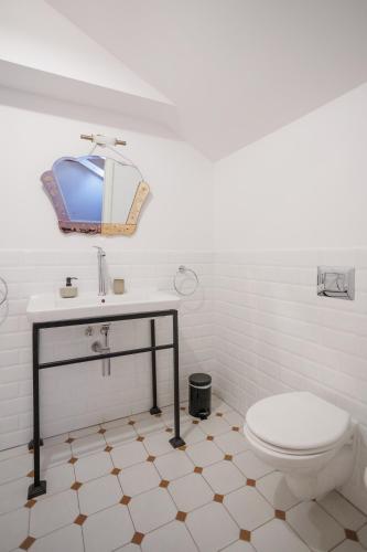 a white bathroom with a sink and a toilet at Zamość Dwór Udrycze in Udrycze