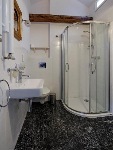 a bathroom with a glass shower and a sink at Zamość Dwór Udrycze in Udrycze