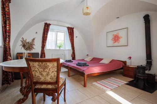 a bedroom with a bed and a table in it at Zamość Dwór Udrycze in Udrycze