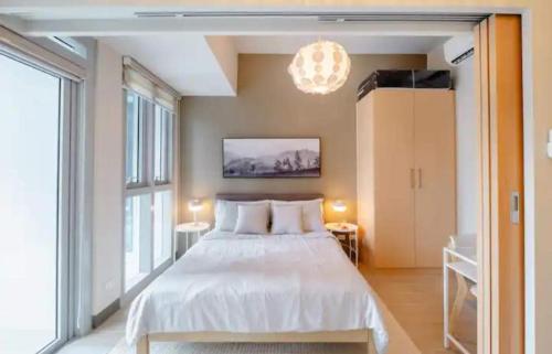 a bedroom with a bed and a large window at Uptown BGC in Manila