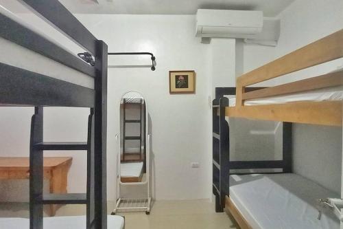 een kamer met 2 stapelbedden en een ladder bij Ann's Guesthouse in Butuan