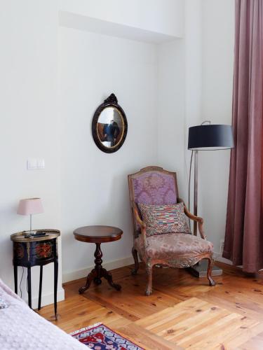 a bedroom with a chair and a table and a mirror at Zamość Dwór Udrycze in Udrycze