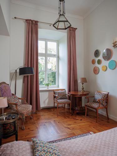 a living room with a table and chairs and a window at Zamość Dwór Udrycze in Udrycze