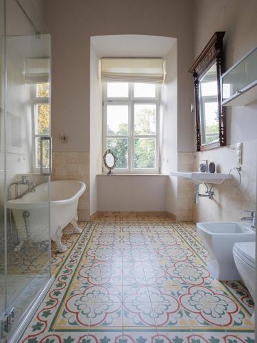 a bathroom with a tub and two sinks and a bath tub at Zamość Dwór Udrycze in Udrycze