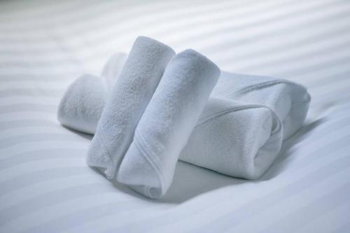 a pile of white towels sitting on a bed at T-home彩 in Tokyo